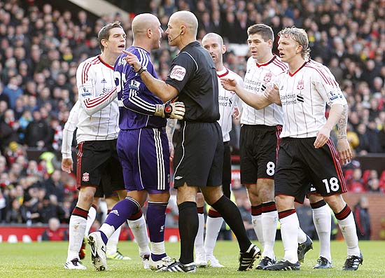 Liverpool's Pepe Reina, second left, and Daniel Agger, left, argue with referee Howard Webb after he awarded a penalty to Manchester United during their third round FA Cup soccer match at Old Trafford, Manchester, England, Sunday Jan. 9, 2011. (AP Photo/Jon Super)