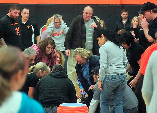 ORG XMIT: MIHOL107 A crowd reacts as paramedics work on Fennville High School basketball player Wes Leonard, after the Michigan high school star collapsed after making a game-winning layup in overtime to cap his team's perfect season, in Fennville, Mich., Thursday, March 3, 2011. Leonard later died. (AP Photo/The Holland Sentinel, Dennis Geppert)