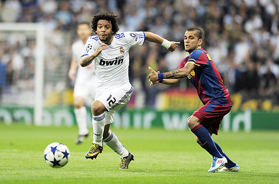 Marcelo (esq.) escapa de Daniel Alves (dir.) no jogo entre Real e Barcelona, no Santiago Bernabu; clique na foto e veja galeria