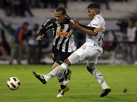 Alan Patrick (esq.) tenta uma jogada para o Santos na partida contra o Once Caldas, na Colômbia