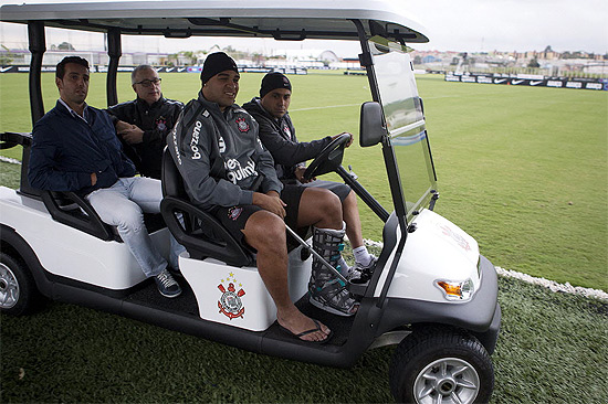 Carrinho transporta Adriano, no banco de passageiro da frente, Edu Gaspar (atrás, à esq.) e Roberto de Andrade (atrás, à dir.)