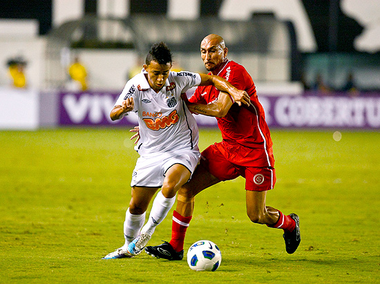 Felipe Anderson (esq.) disputa bola com Guiazu no empate na Vila Belmiro