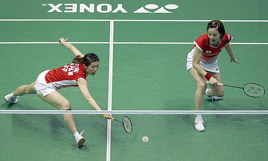 Vestindo saias, as japonesas Satoko Suetsuna (esq.) e Miyuki Maeda jogam na Copa do Mundo de Sudirman, em Qingdao, na China
