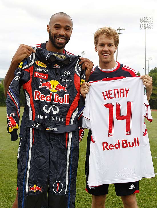 Thierry Henry e Sebastian Vettel posam com o uniforme um do outro