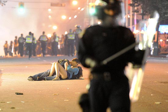 Casal se beija durante conflito de torcedores e policiais em rua de Vancouver; clique na foto e veja galeria