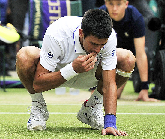 Novak Djokovic come grama após faturar o torneio de Wimbledon; clique na imagem e veja galeria