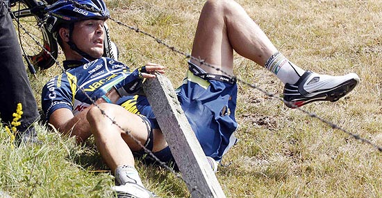 Ainda caído, o ciclista holandês tenta se livrar do arame farpado; clique na foto e veja galeria