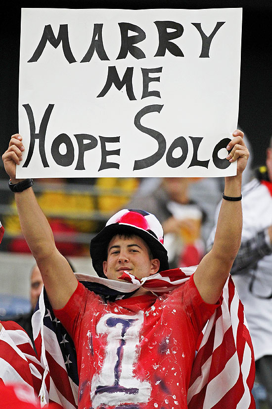 Torecedor exibe cartaz com pedido de casamento à goleira americana Hope Solo.