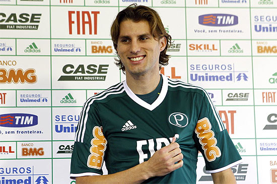 Henrique mostra o escudo da camisa do Palmeiras, sua nova equipe