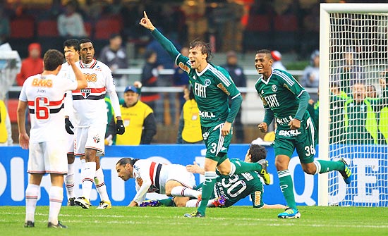 Henrique levanta a mão e comemora o gol do empate do Palmeiras