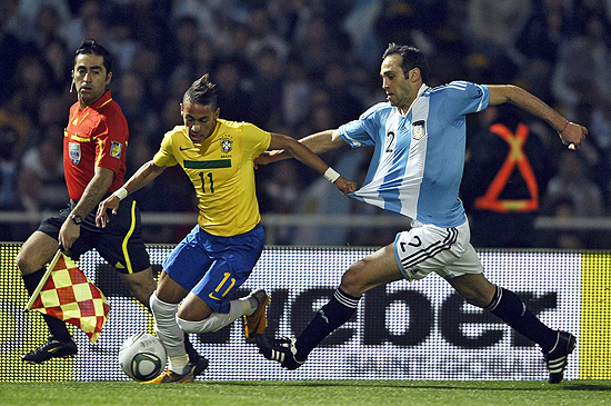 Neymar tenta escapar com a bola e é acompanhado pelo zagueiro Desabato