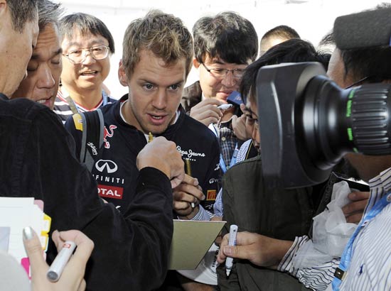 Sebastien Vettel é rodeado por fãs e jornalistas em Sukuza, antes do treino classificatório