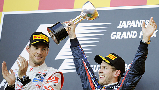 Sebastian Vettel levanta a taa do ttulo de 2011 de F-, enquanto Jenson Button (esq.) aplaude