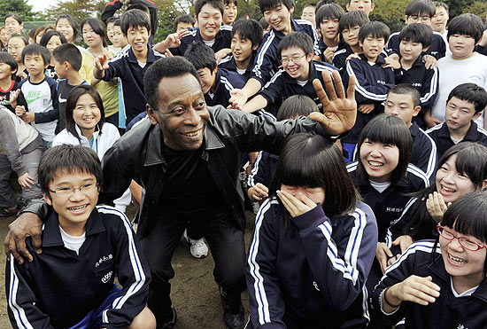 Pelé sorri ao lado das crianças da escola de Natori