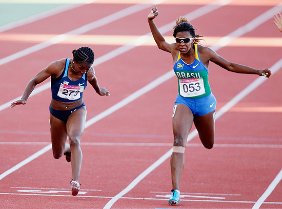Rosângela Santos (à dir.) cruza a linha de chegada na primeira colocação na prova dos 100 m rasos