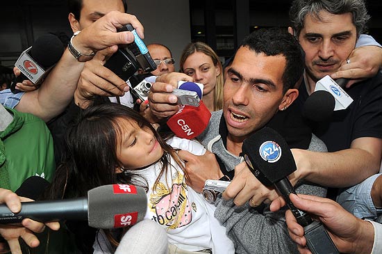 Carlitos Tevez e sua filha Florencia so recpecionados pela imprensa argentina. no Aeroporto de Buenos Aires