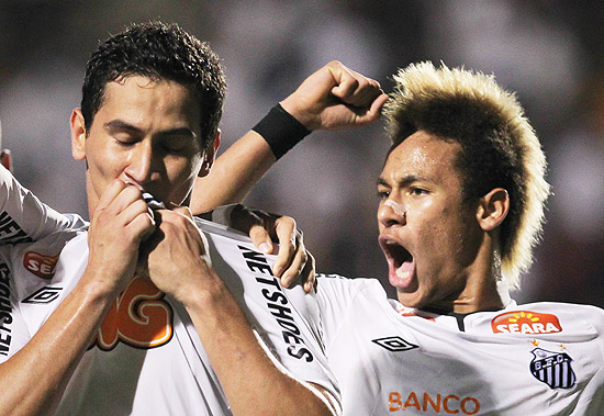 Ao lado de Neymar, Ganso beija a camisa para comemorar o seu gol no Pacaembu