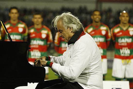 O maestro Joo Carlos Martins, torcedor da Portuguesa, toca o hino nacional em um piano no Canind