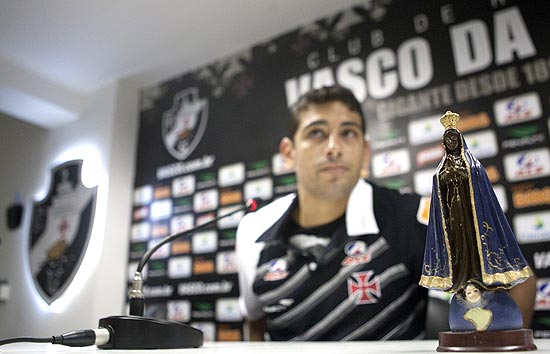 Diego Souza dá entrevista ao lado da imagem de Nossa Senhora Aparecida na sala de imprensa do estádio de São Januário