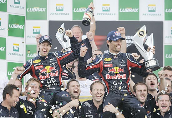 Sebastian Vettel (esq.) e Mark Webber (dir.) comemoram com a equipe da Red Bull resultado no GP Brasil