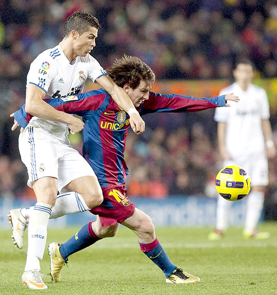 Cristiano Ronaldo (esq.) e Lionel Messi (dir.) disputam a bola no clássico entre Real Madrid e Barcelona