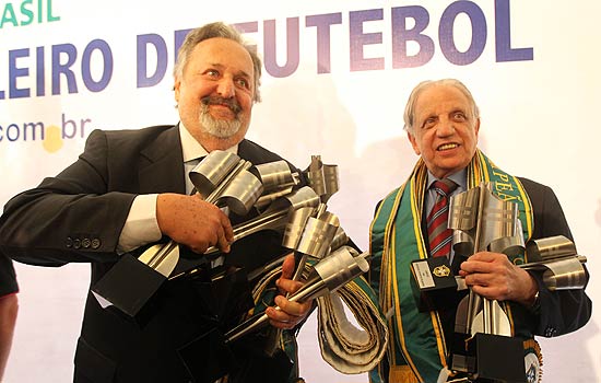 O presidente do Santos, Luis Álvaro (à esq.), e o representante do Palmeiras, Salvador Hugo Palaia, seguram troféus durante a festa da unificação dos títulos nacionais em 2010 