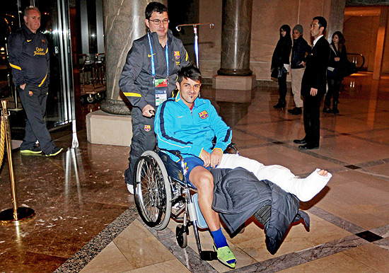 Na cadeira de rodas, David Villa chega ao hotel em Yokohama 