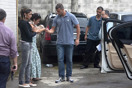 Adrienne, que foi baleada no carro de Adriano, aparece com o braço imobilizado após cirurgia