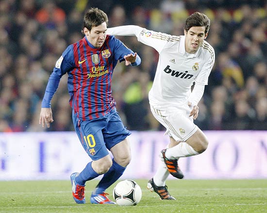 O atacante Messi disputa bola com o meia Kaká; clique na imagem para ver mais fotos