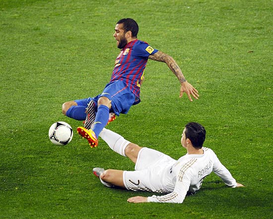 Daniel Alves cai após uma entrada de Cristiano Ronaldo; clique e veja mais fotos do clássico