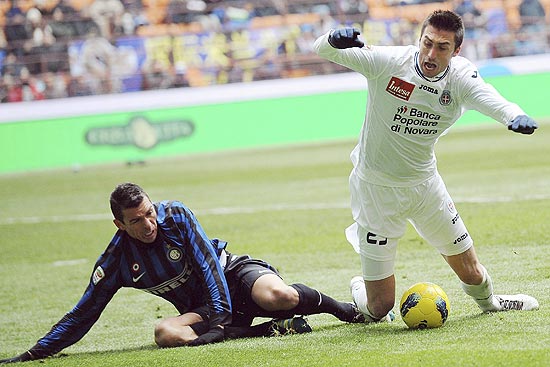 O zagueiro Lúcio, da Inter, comete falta no atacante Caracciolo, do Novara