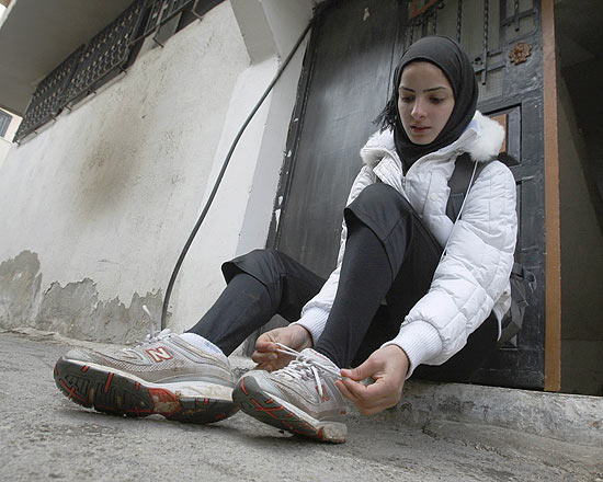 A corredora palestina Worood Maslaha se ajeita antes de começar a treinar na Cisjordânia