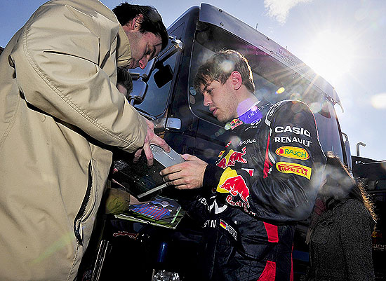 Sebastian Vettel (dir.) d autgrafo no intervalo do treino na Catalunha
