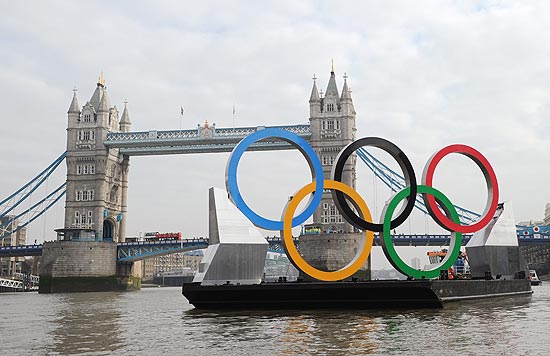 Anéis olímpicos de 11 m de altura por 25 m de comprimento no Rio Tâmisa, próximos à Tower Bridge