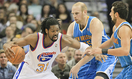 O brasileiro Nenê (esq.) tenta lance de ataque pelo Denver Nuggets na NBA; clique e veja mais fotos