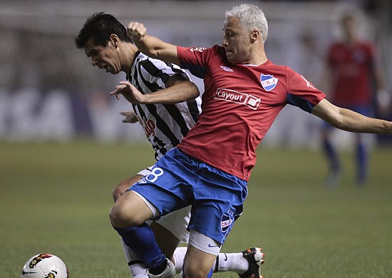 Cceres (esq.), do Libertad, disputa bola com Damonte, do Nacional, em jogo vlido pela Libertadores