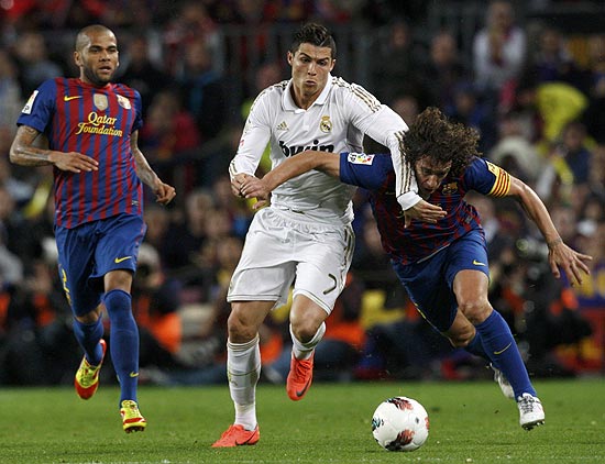 Cristiano Ronaldo disputa bola com Puyol durante o clássico entre Barcelona e Real Madrid