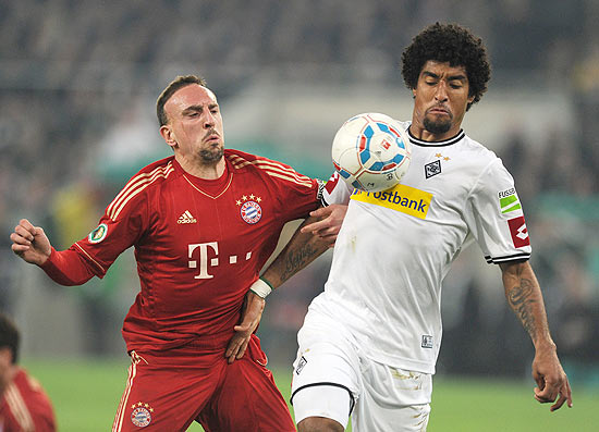 Dante (dir.) tenta dominar a bola marcado por Franck Ribery 