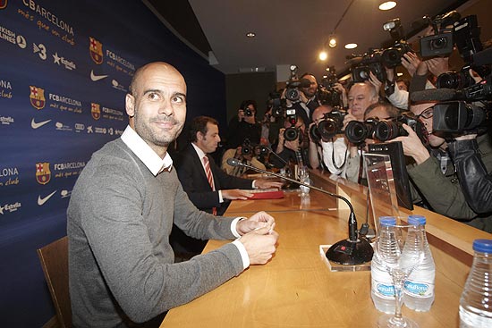 O treinador Pep Guardiola é cercado por fotógrafos e cinegrafistas no anúncio de sua saída do Barcelona