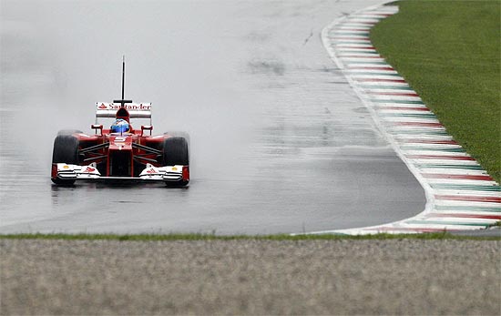 Sob chuva, Fernando Alonso, da Ferrari, em ação na Itália