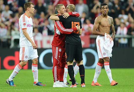 Robben (de preto) abraa Schweinsteiger aps o amistoso entre Bayern de Munique (de branco) e Holanda