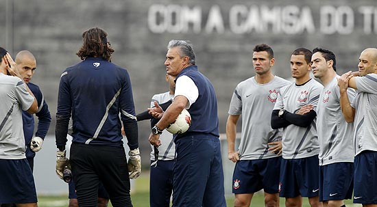 Com a bola no braço, Tite conversa com jogadores do Corinthians