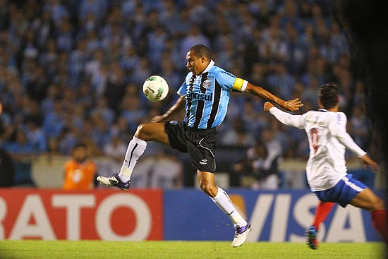 Gilberto Silva se esforça para tentar dominar a bola