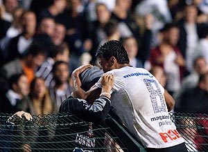 Paulinho comemora o gol da vitória com um torcedor, no alambrado
