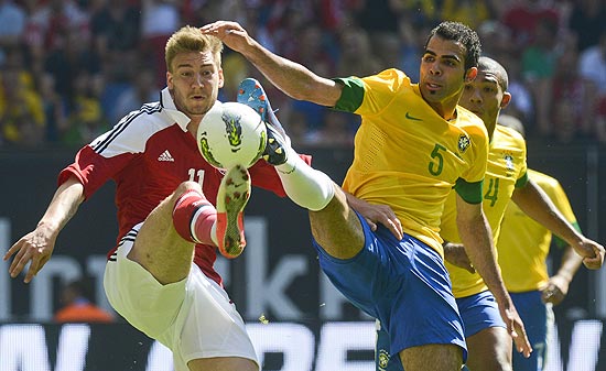 O volante Sandro (dir.), do Brasil, disputa bola com o atacante Bendtner, da Dinamarca