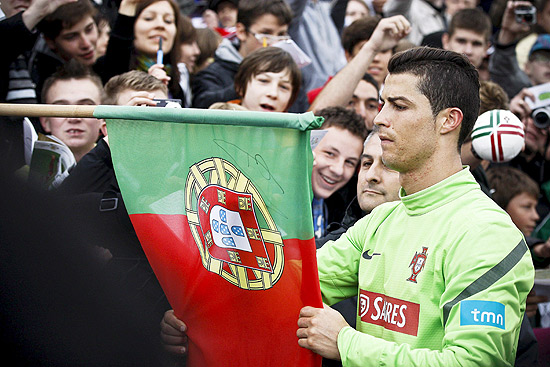 Cristiano Ronaldo autgrafa bandeira de Portugal aps treino da seleo na Polnia