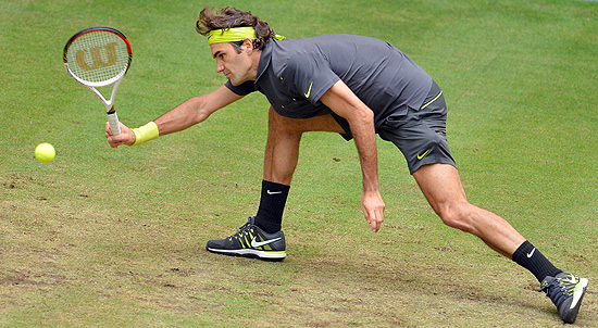 O suo Roger Federer tenta salvar um ponto na partida contra o russo Mikhail Youzhny
