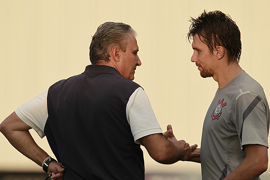 Tite (esq.) conversa com o zagueiro Paulo André durante treino do Corinthians