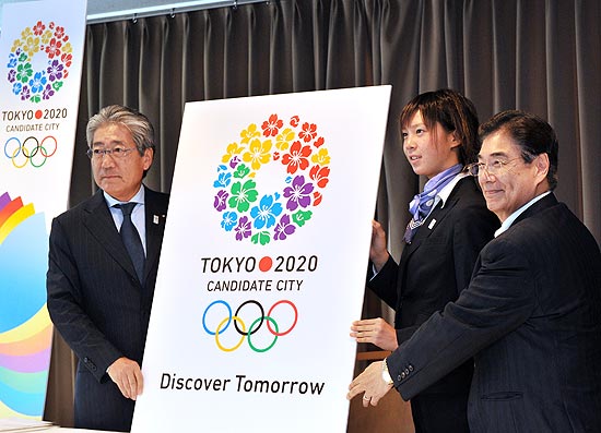 O presidente do comit de candidatura de Tquio-2020, Tsunekazu Takeda, o triatleta japons Yuka Sato e o chefe do comit Masato Mizuno revelam o slogan "Descubra o Amanh"