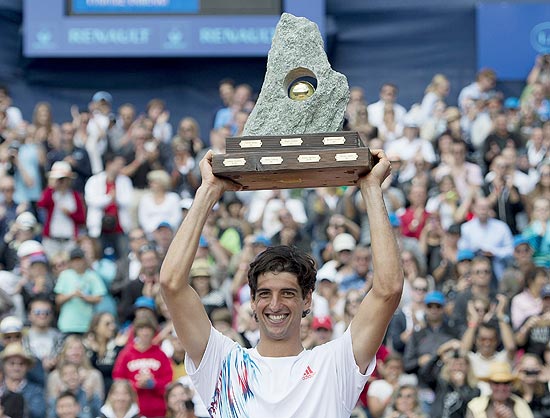 O tenista brasileiro Thomasz Bellucci levanta o troféu de campeão após vencer Janko Tipsarevic